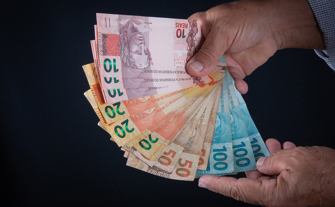 Man holding Brazilian money banknotes Finance concept