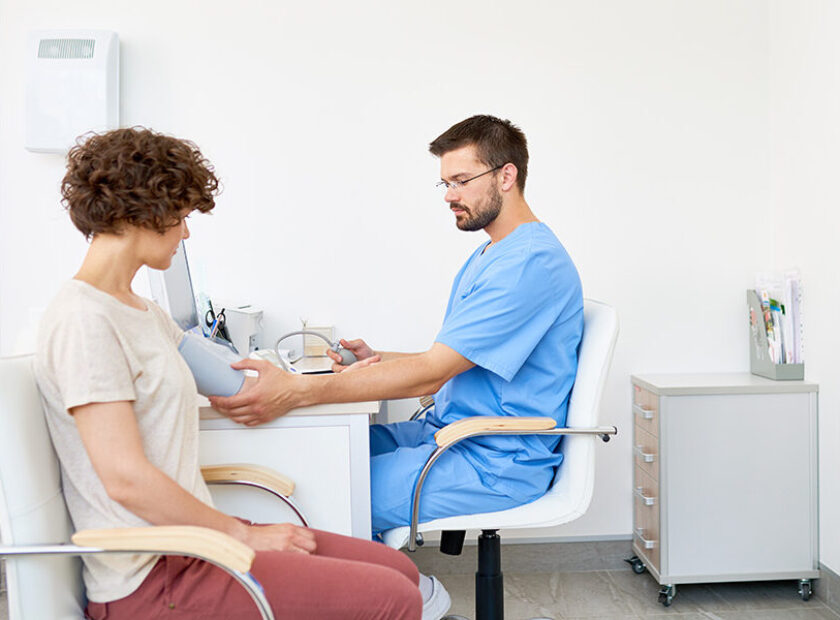 Doctor Measuring Blood Pressure on Patient