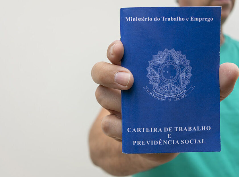 Man holding Brazilian job card, with space for text.