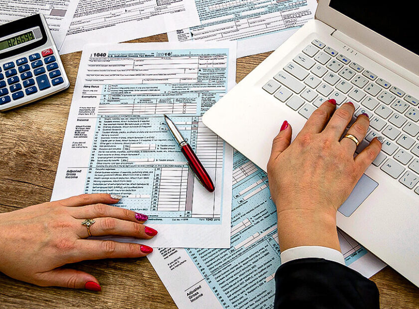 Tax form 1040 human hands and laptop